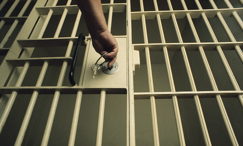 ca. 1980-2003 --- Key in Jail Cell Door --- Image by © Charles O'Rear/CORBIS